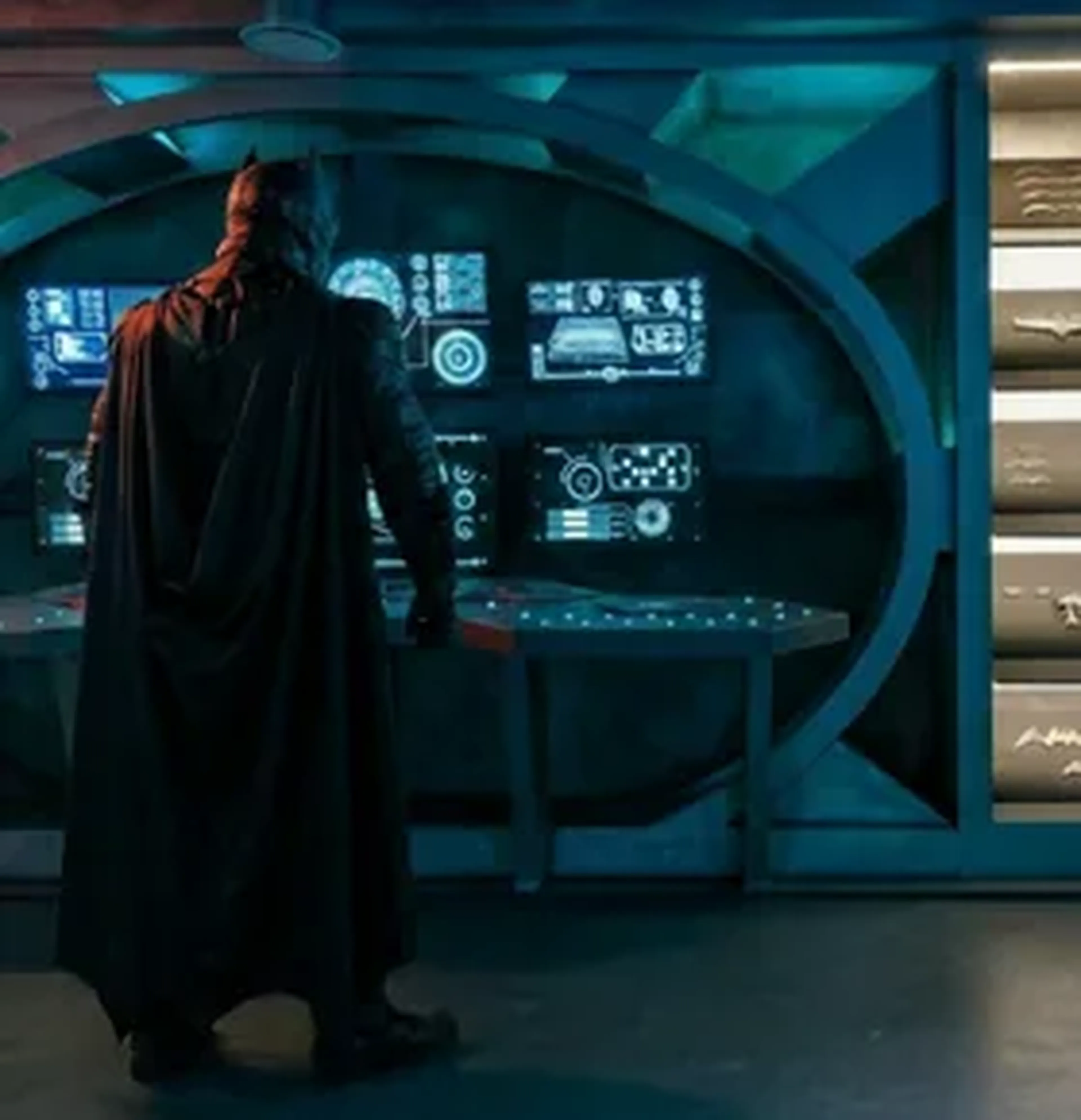 Vue d'ensemble du décor de la Batcave avec écrans interactifs et costume de Batman