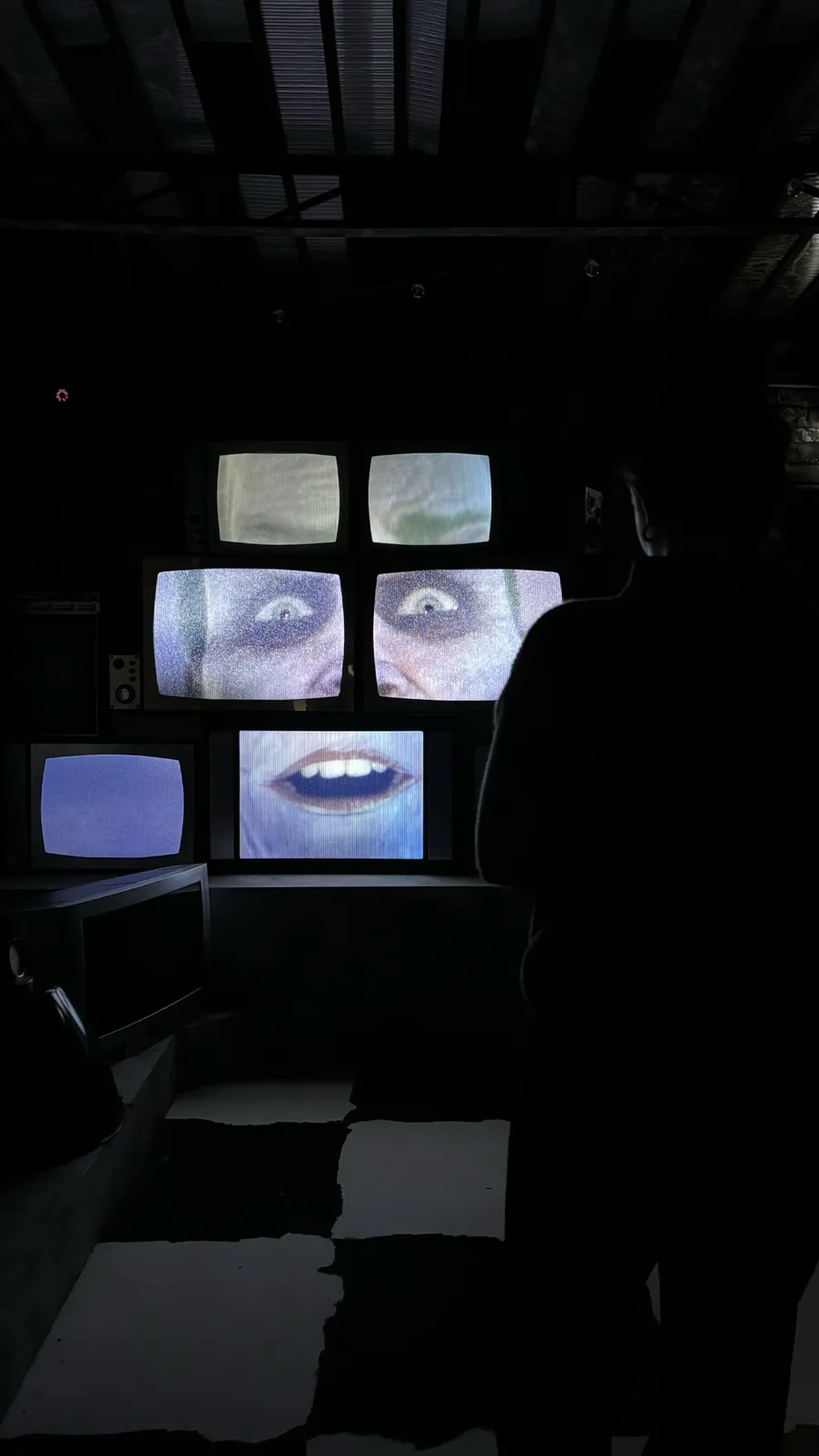 Wall of vintage TV screens in the immersive set of the escape game The Joker in Paris